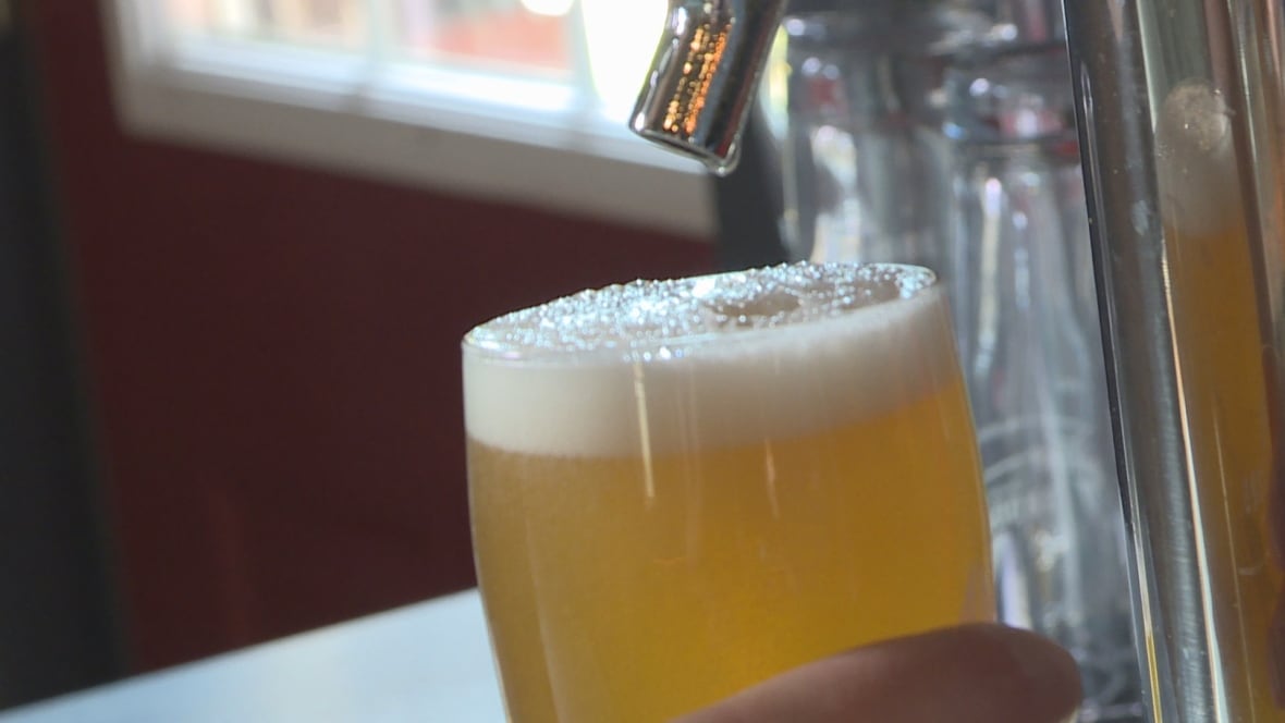 Beer pours out of a tap into a glass.