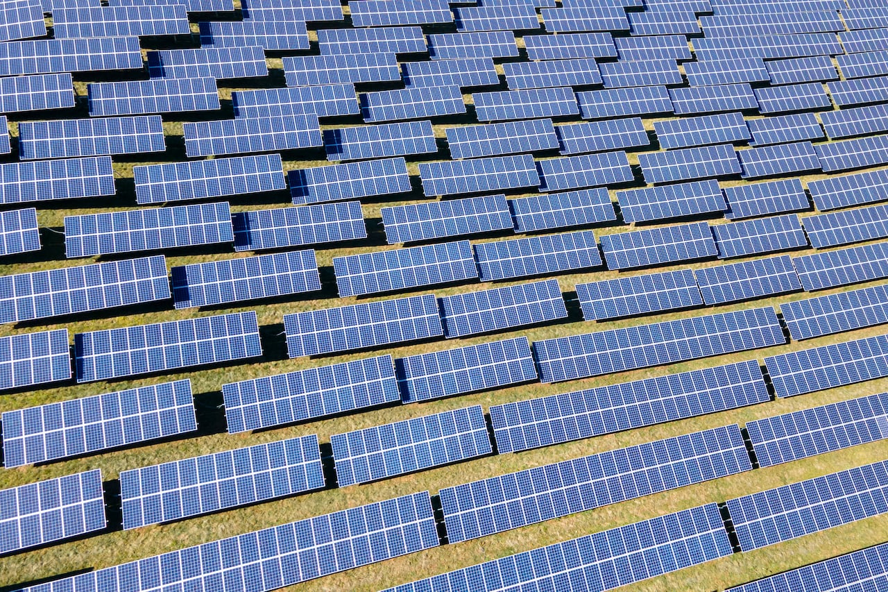 Several solar panels cover a field.