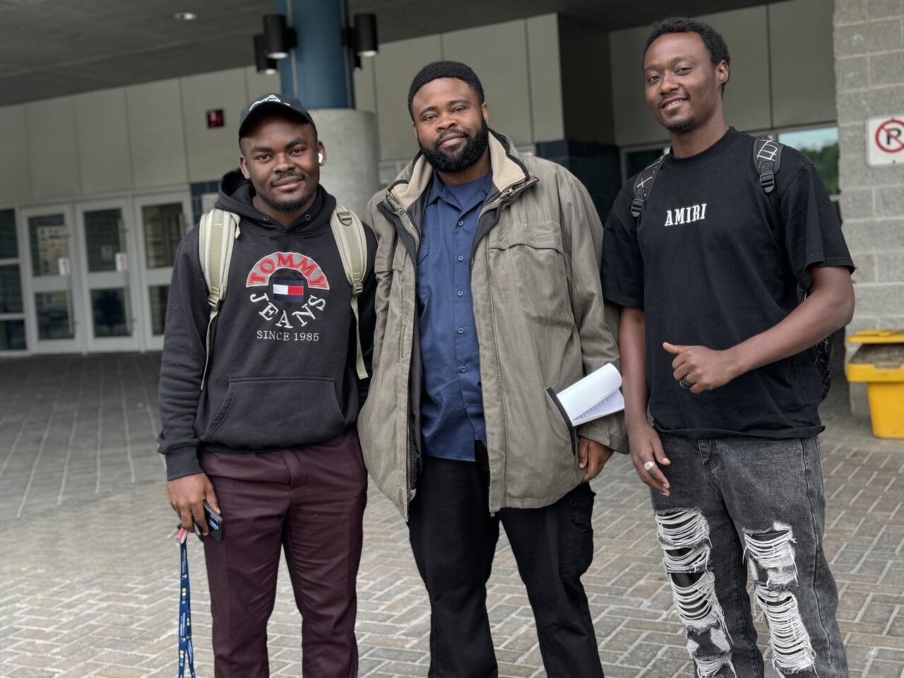 Three young men outside a school.