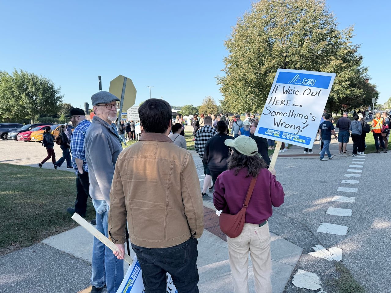 People standing outside holding signs.