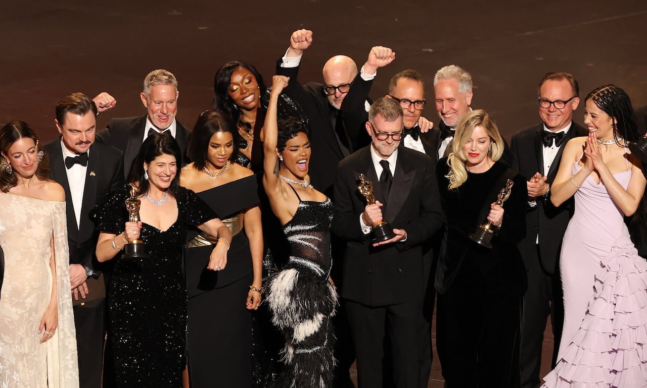 default-337 A group of people embrace and look excited on a stage.