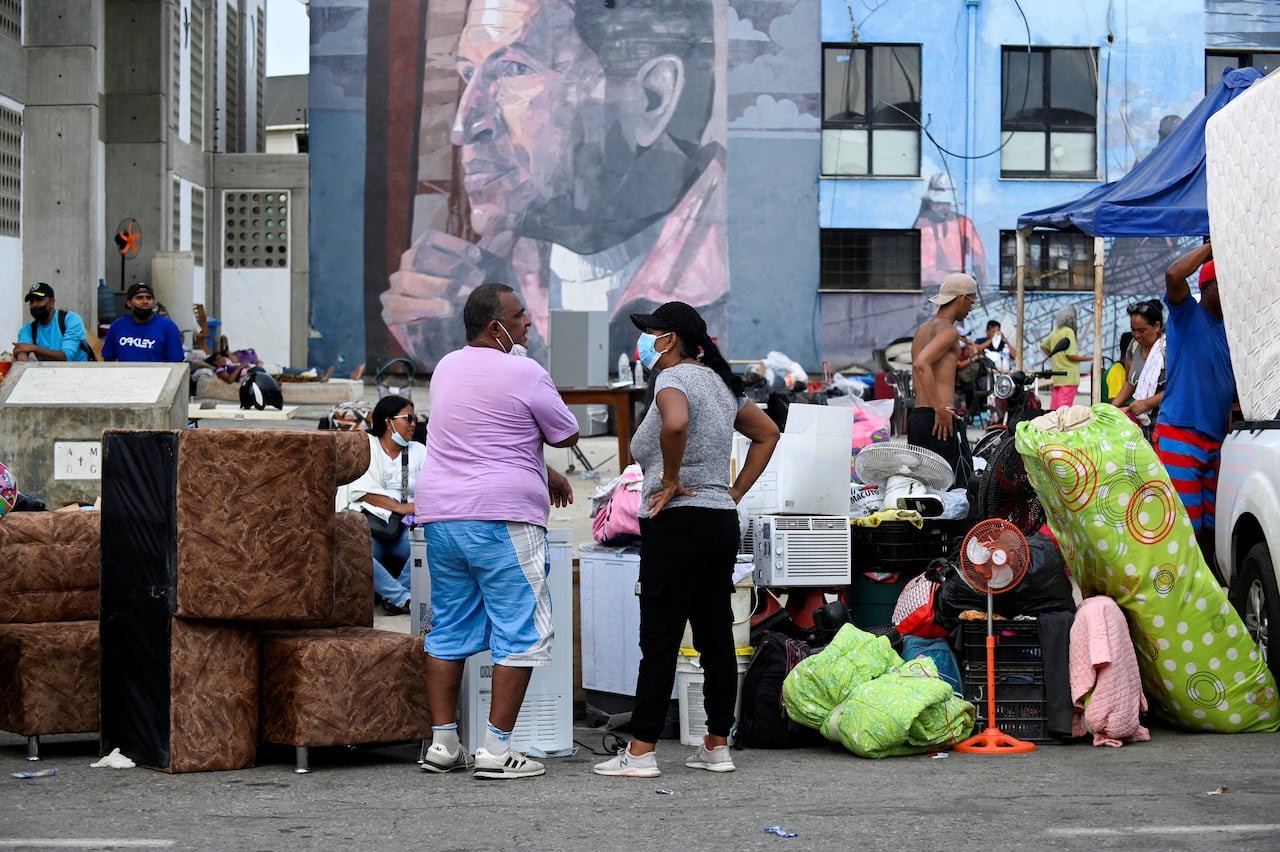 default-357 People stand with their belongings outside.